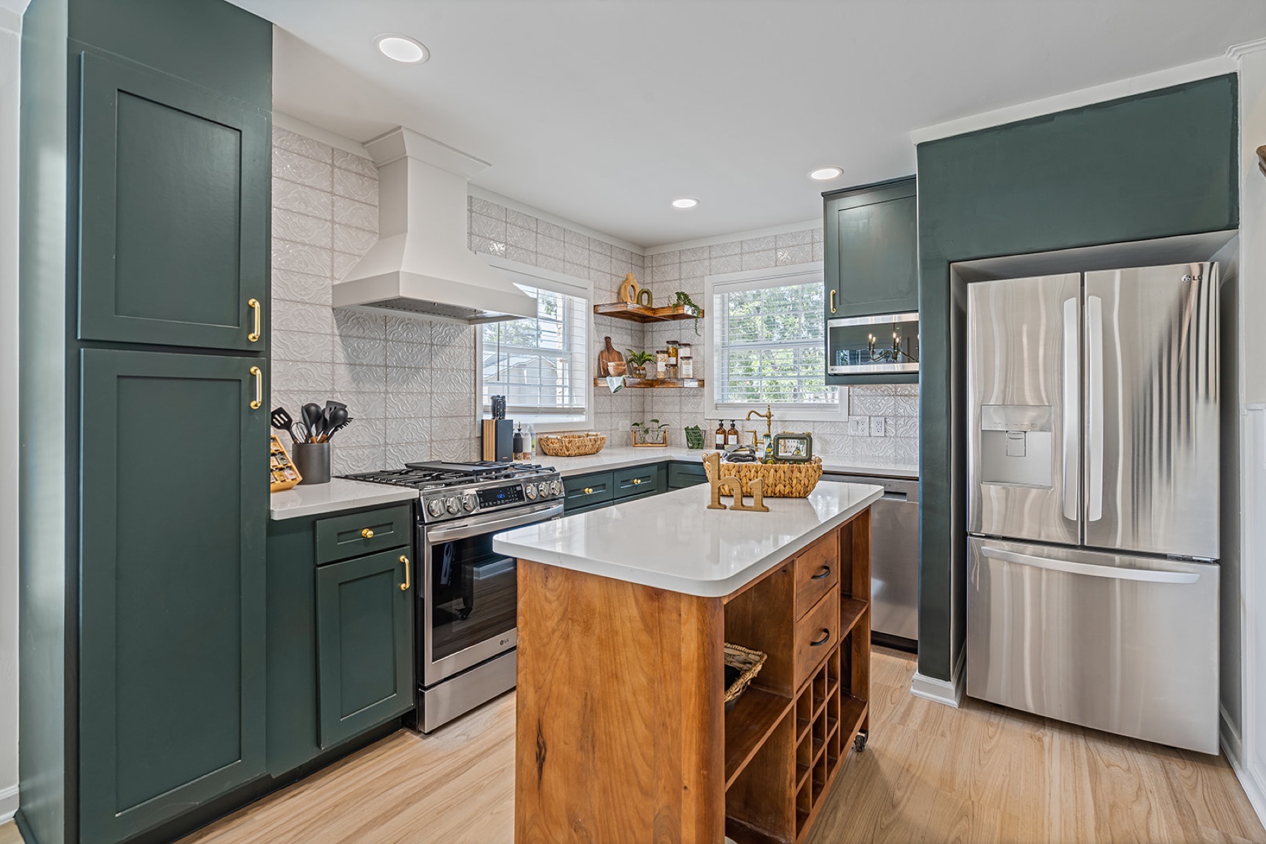 Fully stocked cottage kitchen with green cabinets and center island